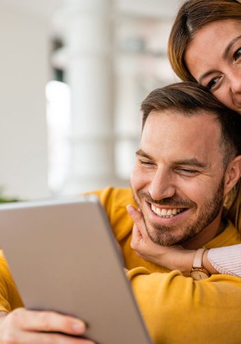 Casal feliz usando tablet em casa com internet Log-Fi